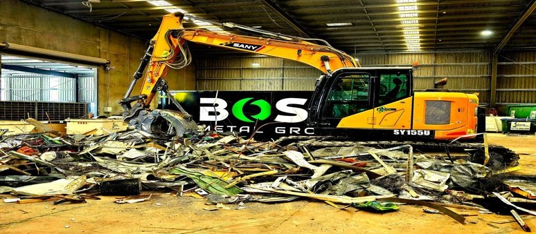 Workers sorting and recycling scrap metal from a demolition site to improve waste management and material recovery.